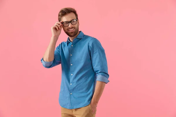 Chico casual feliz mirando a un lado y la fijación de gafas —  Fotos de Stock