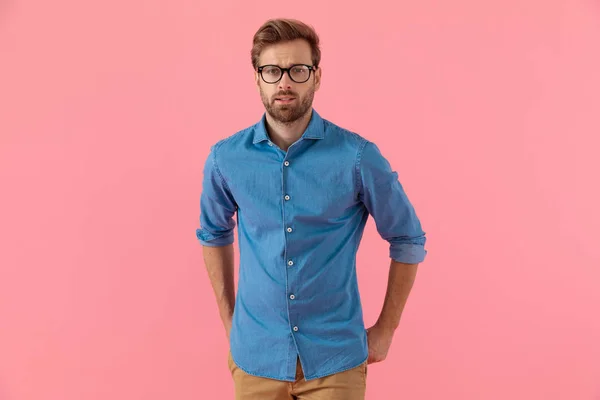 Confused casual guy in denim shirt wearing glasses — Stock Photo, Image