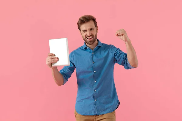 Excited casual man holding tab and celebrating victory — 스톡 사진