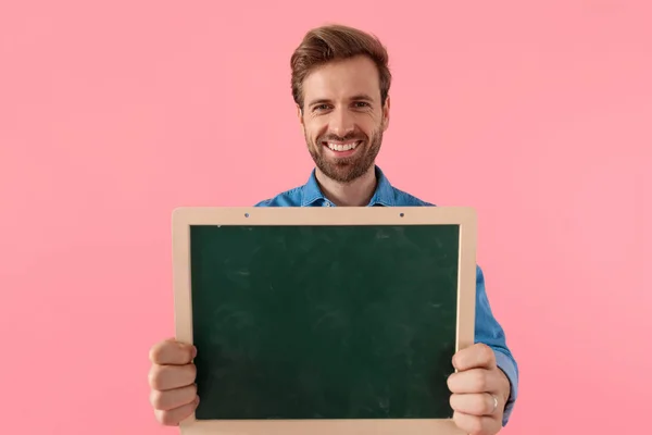 Glad ung kille ler och håller svarta tavlan — Stockfoto