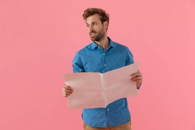 Genç, sıradan bir adam gazeteye bakıyor.