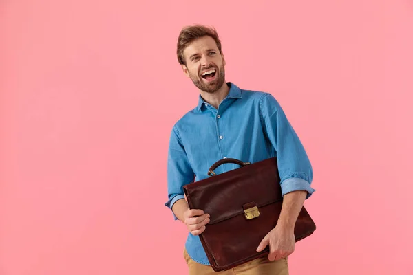 Opgewonden casual guy holding koffer en lachen — Stockfoto