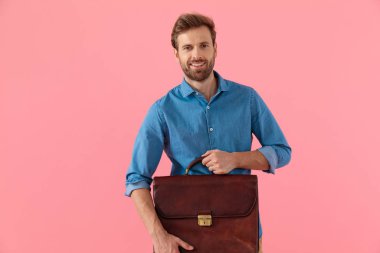 happy casual man smilng and holding suitcase
