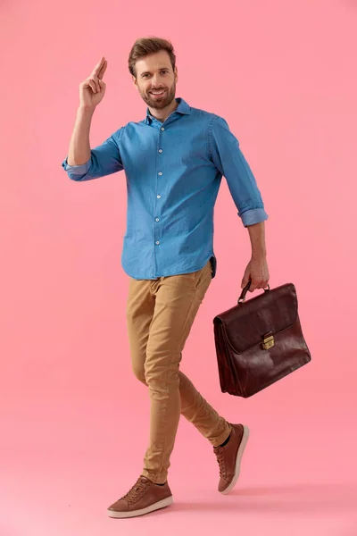 Glücklicher junger Kerl im Jeanshemd mit Koffer und militärischem Sal — Stockfoto