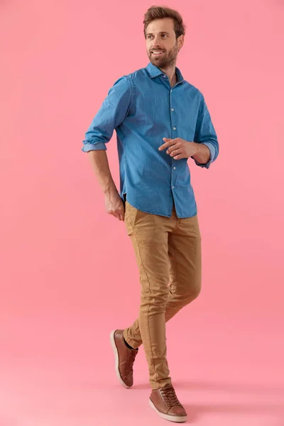 Junger, lässiger Mann im Jeanshemd, der spazieren geht und lächelt — Stockfoto
