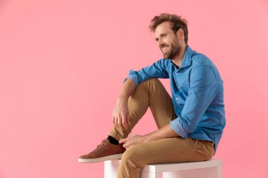 happy casual man in denim shirt looking to side and smiling
