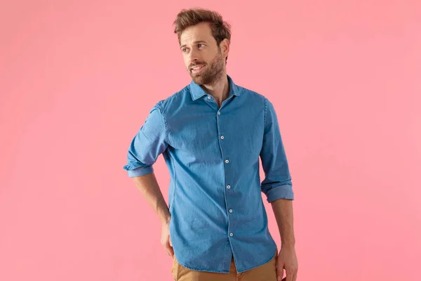 Hombre joven casual en camisa de mezclilla mirando a un lado y sonriendo —  Fotos de Stock