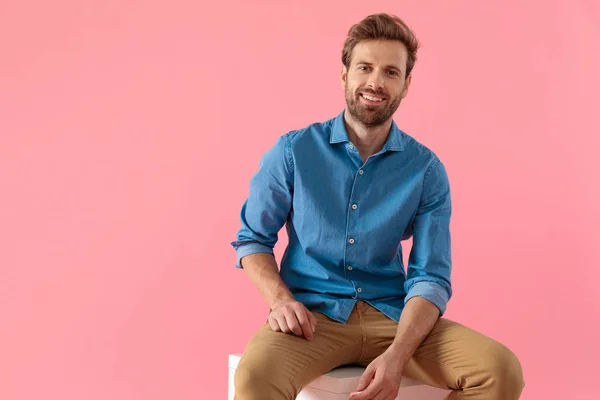 Feliz hombre casual en camisa de mezclilla sonriendo y sosteniendo el codo en thi —  Fotos de Stock