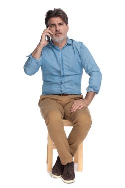 Telefonla konuşan ve kaşlarını çatan sıradan bir adam. 