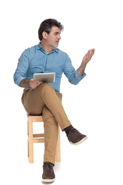 Bossy ležérní muž vysvětlující a držící svůj tablet — Stock fotografie