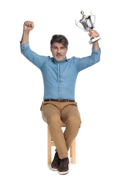 Vrolijke casual man met een trofee en vieren — Stockfoto