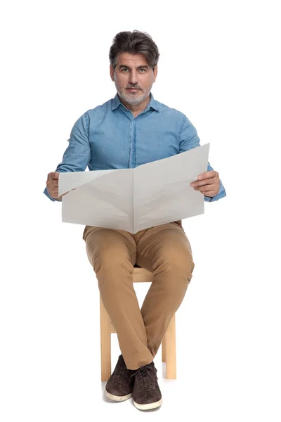 Fröhlicher, lässiger Mann, der Zeitung liest und lächelt — Stockfoto