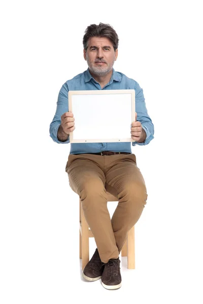 Sebevědomý ležérní muž drží tabuli a těší se — Stock fotografie