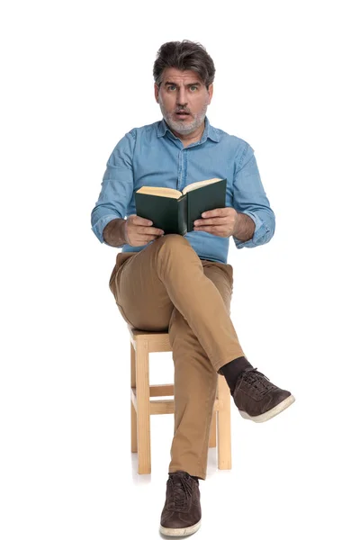 Lenyűgöző alkalmi ember olvas egy könyvet, és zihálva — Stock Fotó