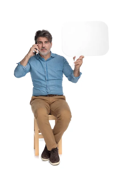 Magabiztos alkalmi ember beszél telefonon és tartja beszéd buborék — Stock Fotó