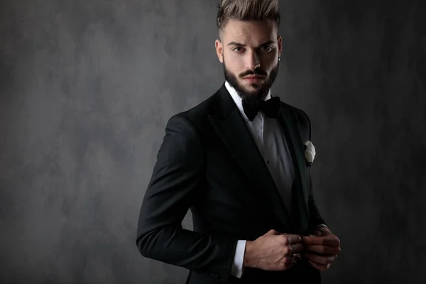 Businessman standing and unbbutoning his jacket serious — Stok fotoğraf
