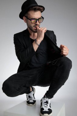 sexy young man biting finger and pulling coat