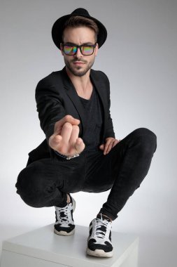 cool dramatic man holding hand in a fashion pose