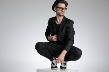 sexy young man holding coat and looking to side