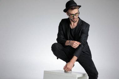 cool dramatic guy holding elbow in a fashion pose