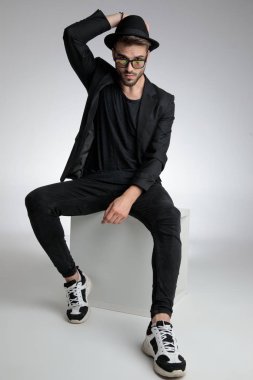 confident young man holding arm in a fashion pose