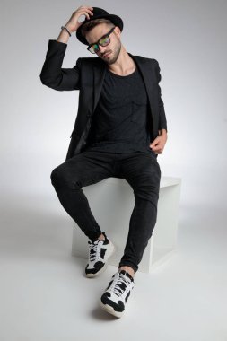 cool dramatic man pulling hat down and posing