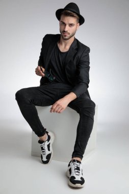 sexy cool guy sitting in a fashion pose