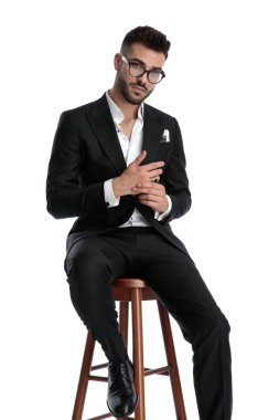 formal business man sitting and rubbing hands serious