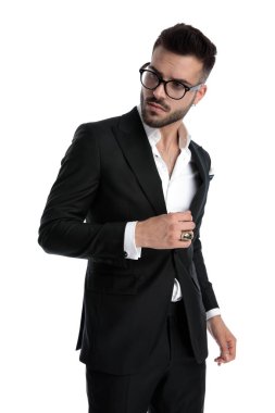 businessman standing and looking aside with loose hands