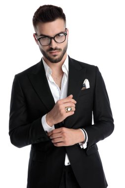 businessman standing and fixing his sleeve confident