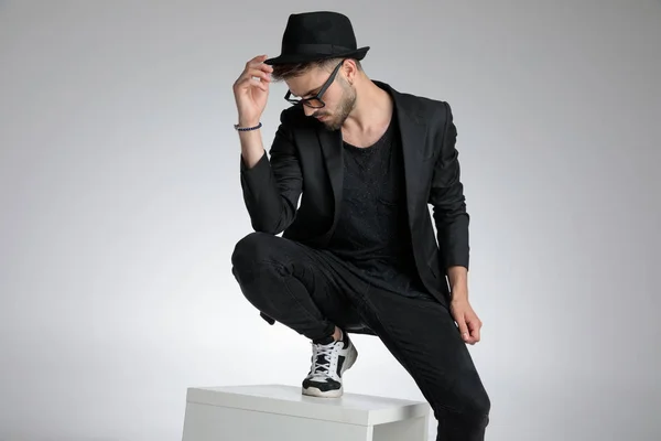 Mysterious young guy holding hat and looking down — ストック写真