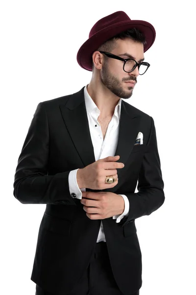 Formal business man standing and fixing sleeve while looking asi — Stockfoto