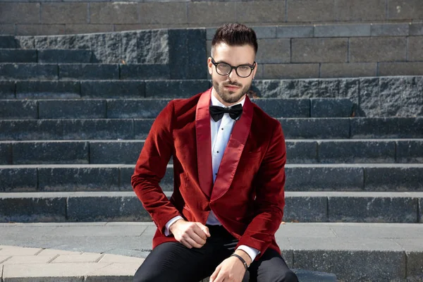 Elegante uomo casual in velluto rosso smoking seduto sulle scale — Foto Stock