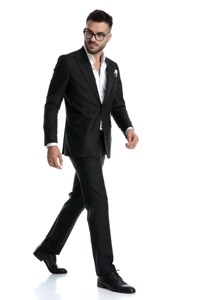 Formal business man walking one way while looking the other — Stockfoto