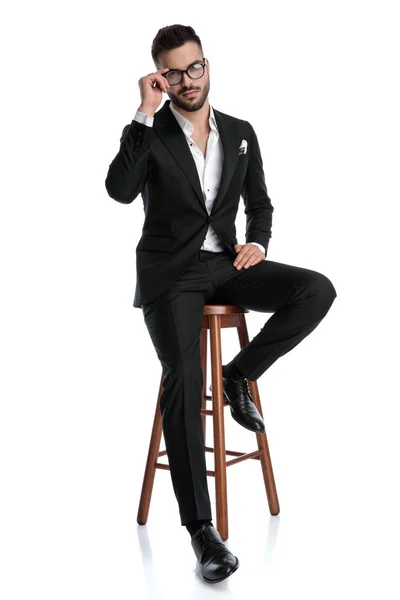 Homem de negócios formal sentado e fixando óculos — Fotografia de Stock
