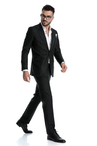Formal business man walking one way while looking the other Stock Photo