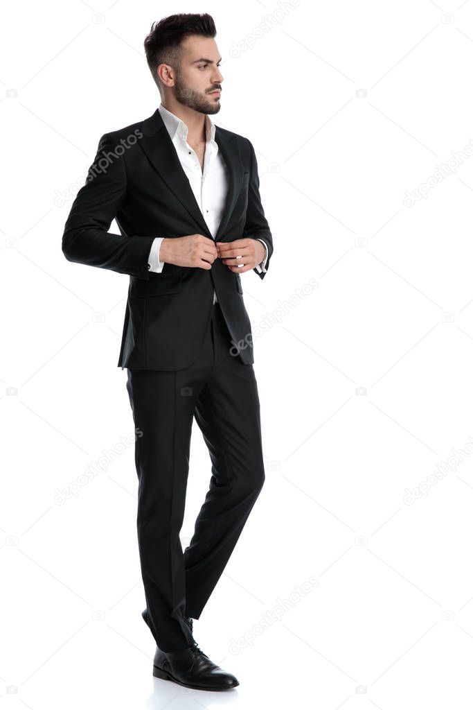 businessman walking and fixing his jacket's button