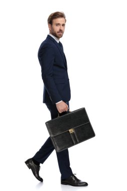 Bavul tutan lacivert takım elbiseli seksi genç işadamı.
