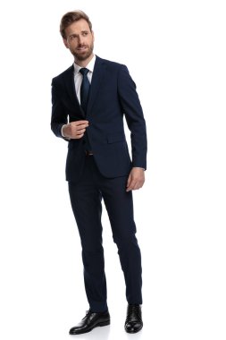 Seksi genç işadamı ceketini ayarlamaya çalışıyor.