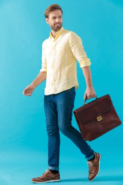 Casual man holding a briefcase and looking over his shoulder