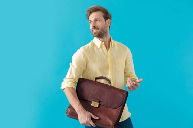 Handsome casual man holding a briefcase and explaining