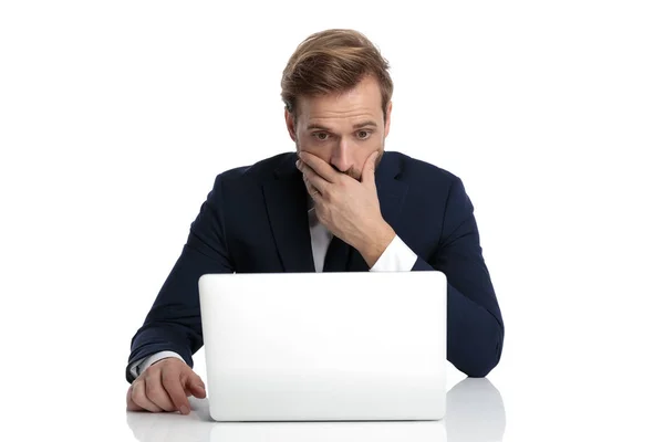 Shocked young businessman in navy suit covering mouth with hand — Stock Photo, Image