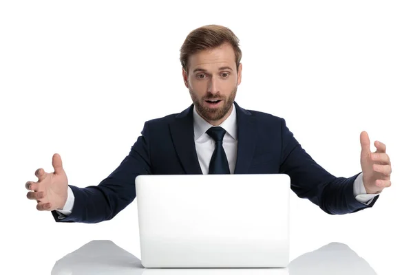 Удивленный молодой бизнесмен в темно-синем костюме читает электронные письма — стоковое фото