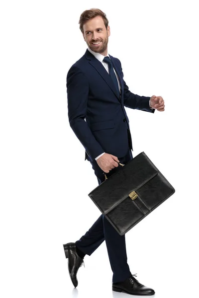 Сексуальний молодий бізнесмен посміхається і тримає валізу — стокове фото