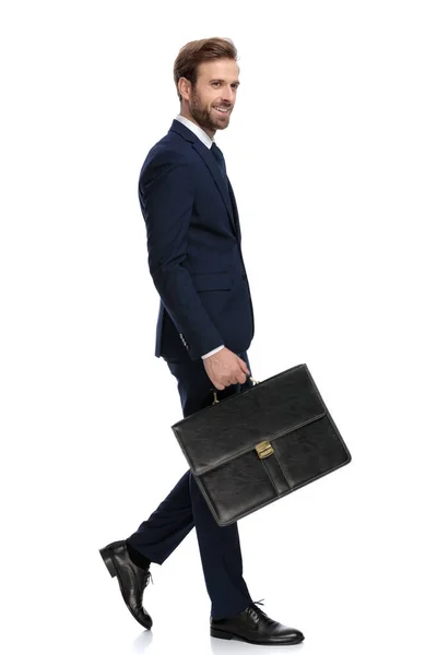 Homme d'affaires heureux en costume bleu marine tenant valise — Photo