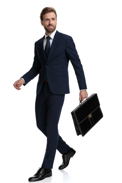 Confident businessman in navy blue suit holding suitcase — 스톡 사진