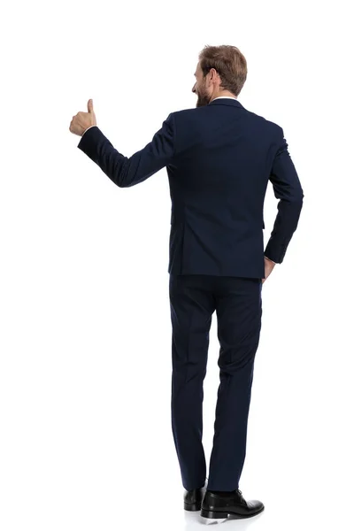 Happy businessman in navy blue suit making thumbs up sign to sid — Stock Photo, Image