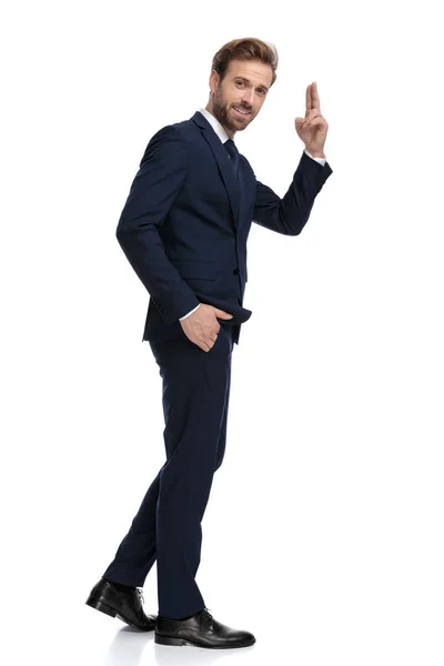 Young businessman in navy blue suit military saluting — Stock Photo, Image