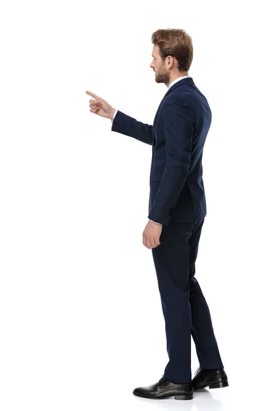 Ung affärsman i marinblå kostym pekar finger åt sidan — Stockfoto