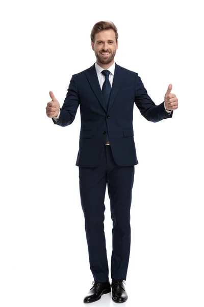 Smiling young businessman making thumbs up sign — Stock Photo, Image